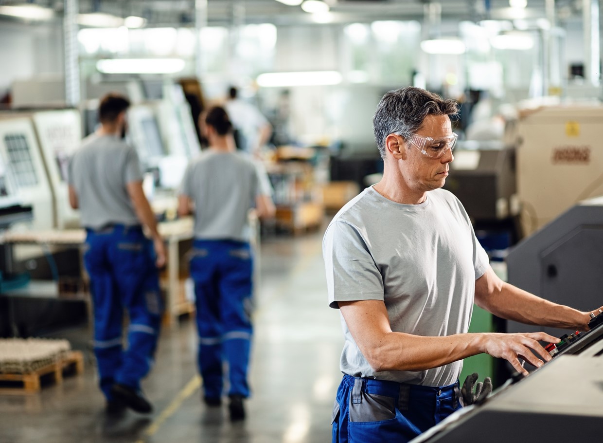 Mid Adult Worker Operating Cnc Machine While Working Industrial Facility